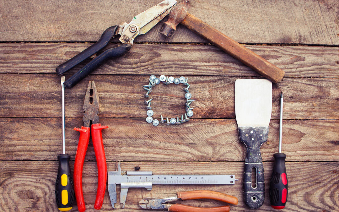 Construction tools in the form of house on wooden background.